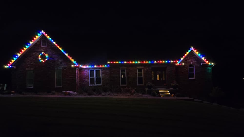 Brick ranch outlined in multicolor C9 bulbs with a lit wreath